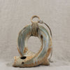 Ceramic wall hook with rustic finish on a textured gray background