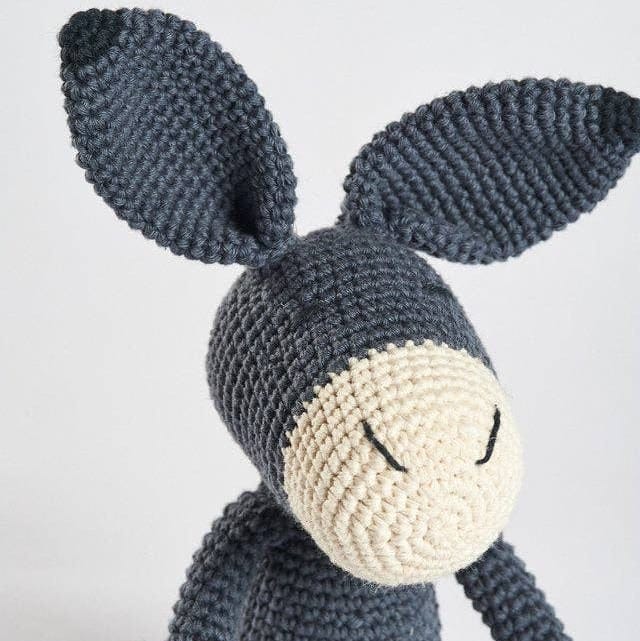 Crocheted donkey toy on a white background
