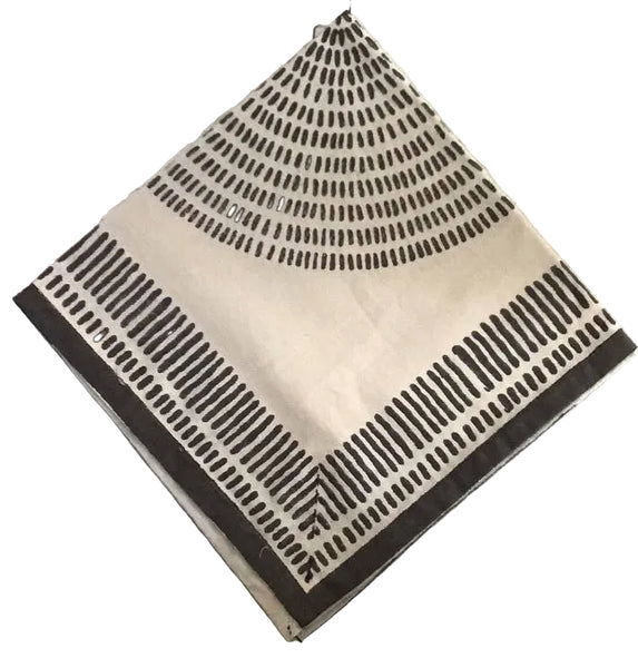 Beige square napkin with black geometric pattern on a light gray textured surface