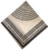 Beige square napkin with black geometric pattern on a light gray textured surface
