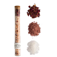 Spa product with a tube and various bath salts on a light gray background