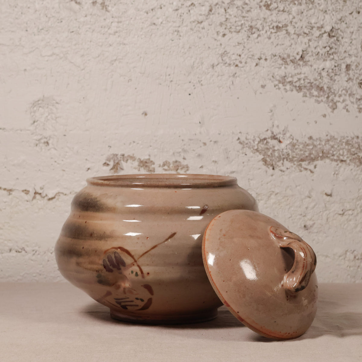 Ceramic jar with lid on a textured surface