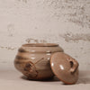 Ceramic jar with lid on a textured surface