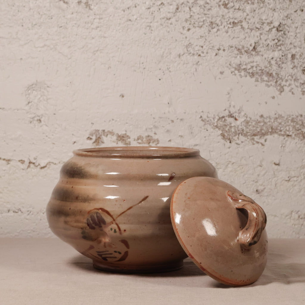 Ceramic jar with lid on a textured surface