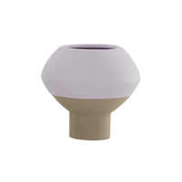 A modern, minimalist ceramic planter or vase with a two-tone design, featuring a matte light lavender upper half and a warm beige lower half, set against a plain white background.