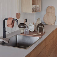 Modern kitchen with sink, countertop, and wooden shelves.