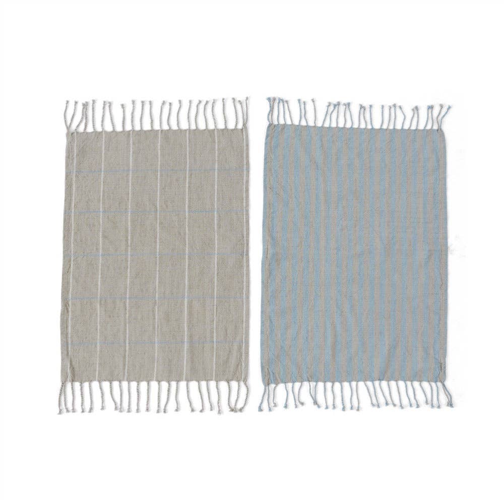 Two woven towels with fringe on a white background