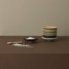 Stacked ceramic plates on a brown surface with a beige wall background