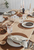 Dining table set with plates, glasses, and cutlery in a home setting.