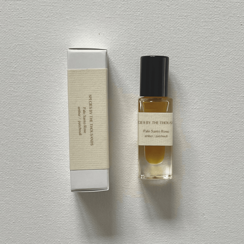 Perfume bottle and packaging on a textured gray surface