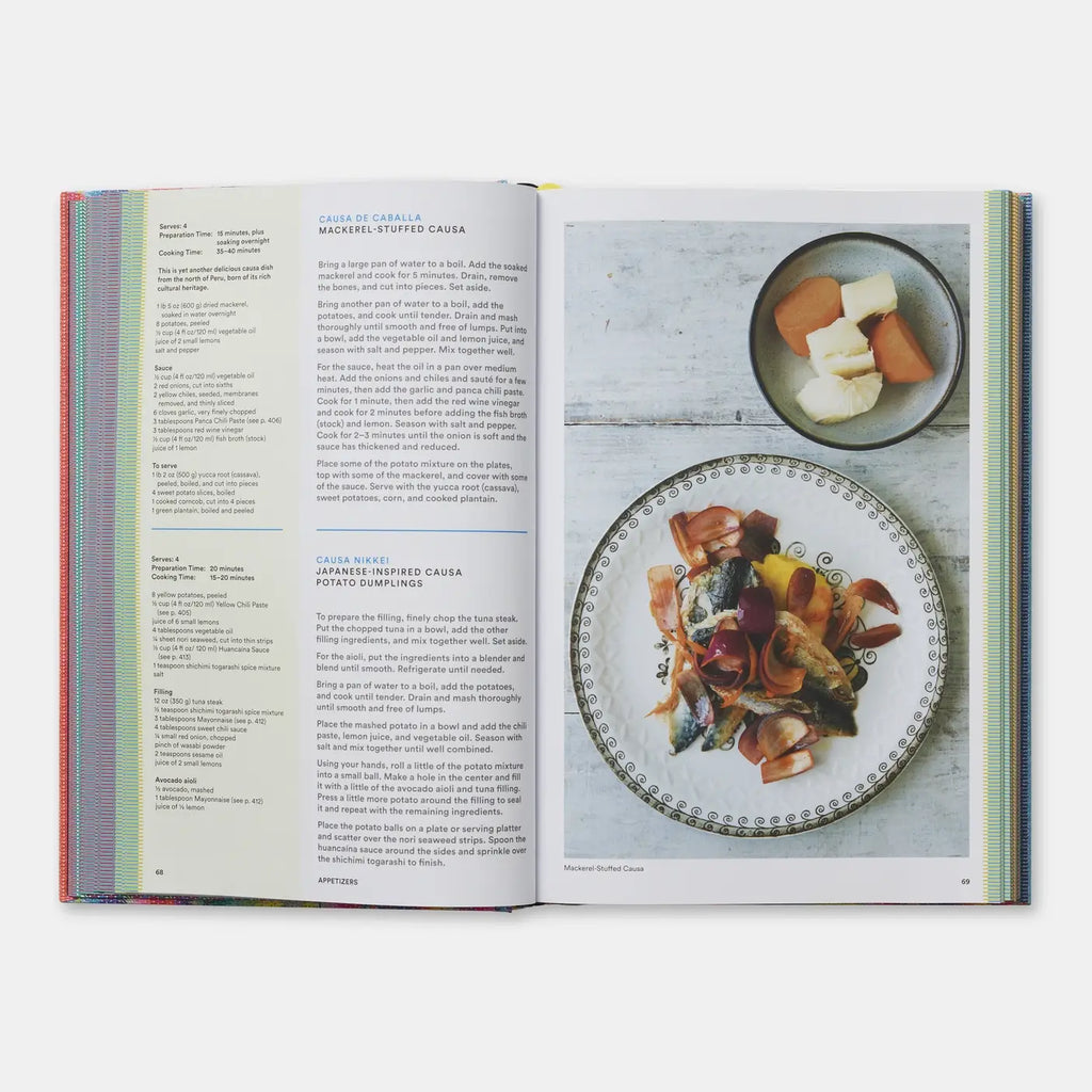 An open cookbook spread showing printed recipe pages with text and a food photograph of prepared pasta on a plate, photographed against a light neutral background.