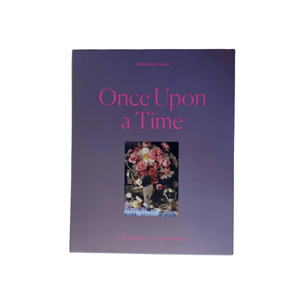 The front cover of the 'Once Upon a Time' 1000-piece puzzle book, featuring a dark purple background with pink title text and a central floral illustration, shown against a plain white background.