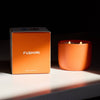 Orange candle and box with 'Fushimi' branding on a dark background