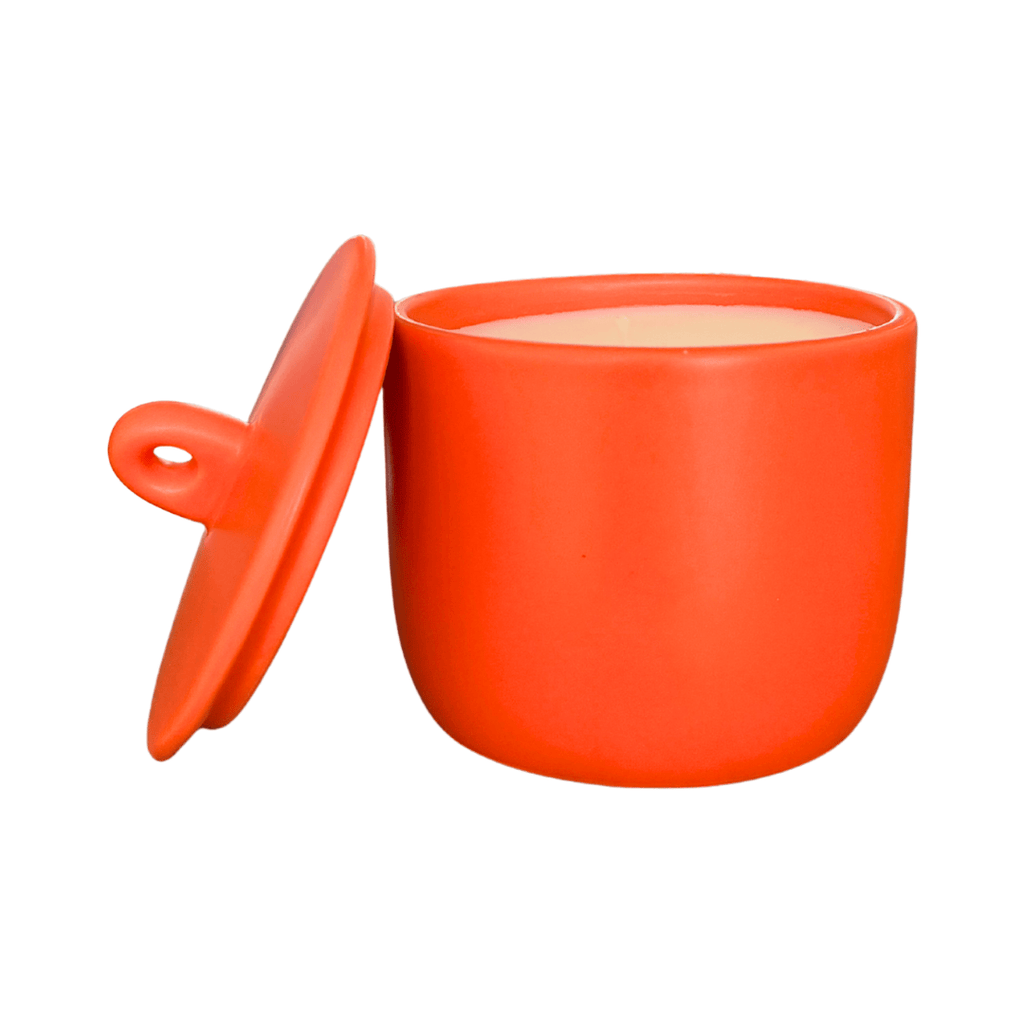 Orange ceramic pot with lid on a white background