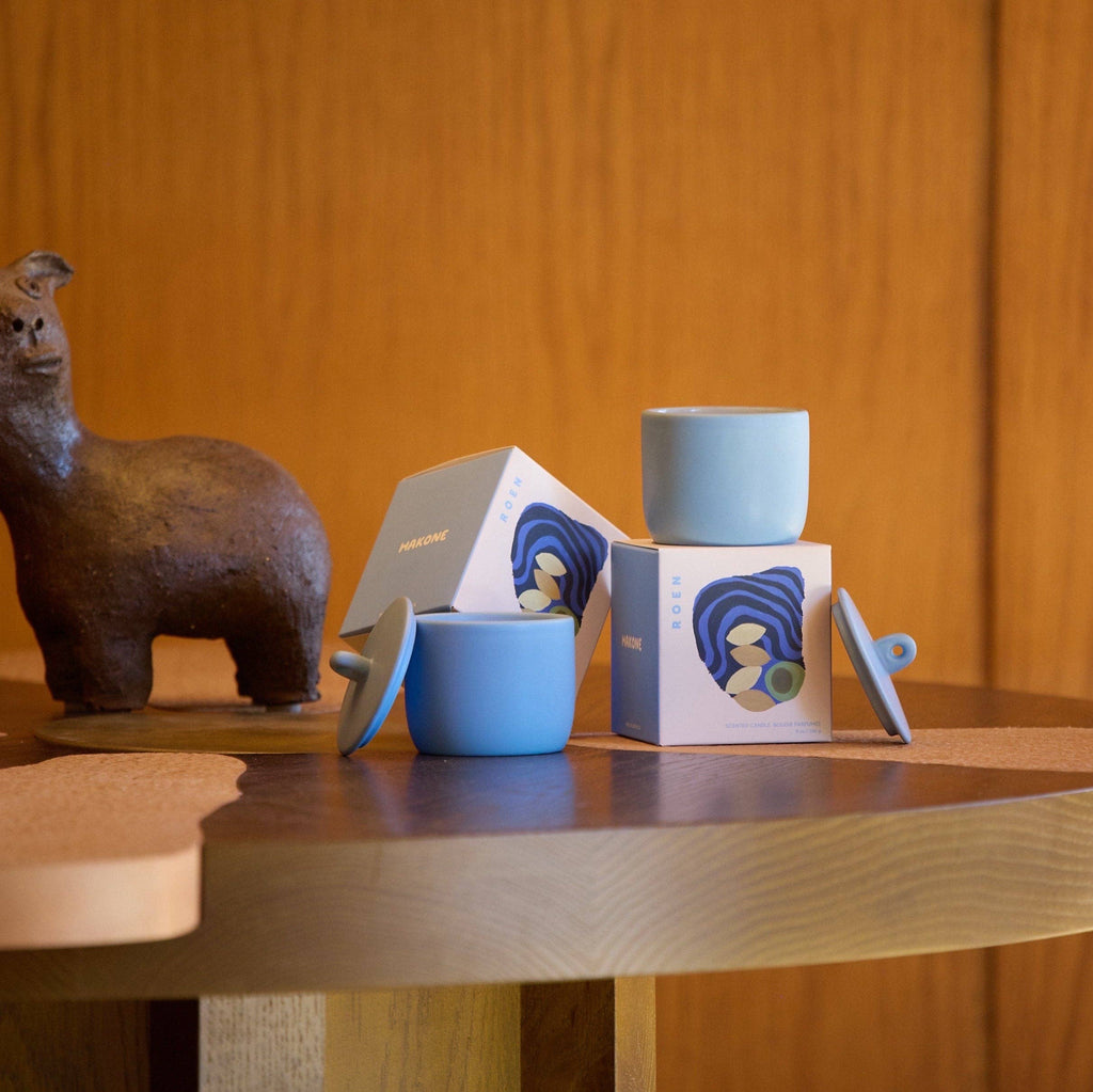 Two blue ceramic cups with their packaging on a wooden surface.