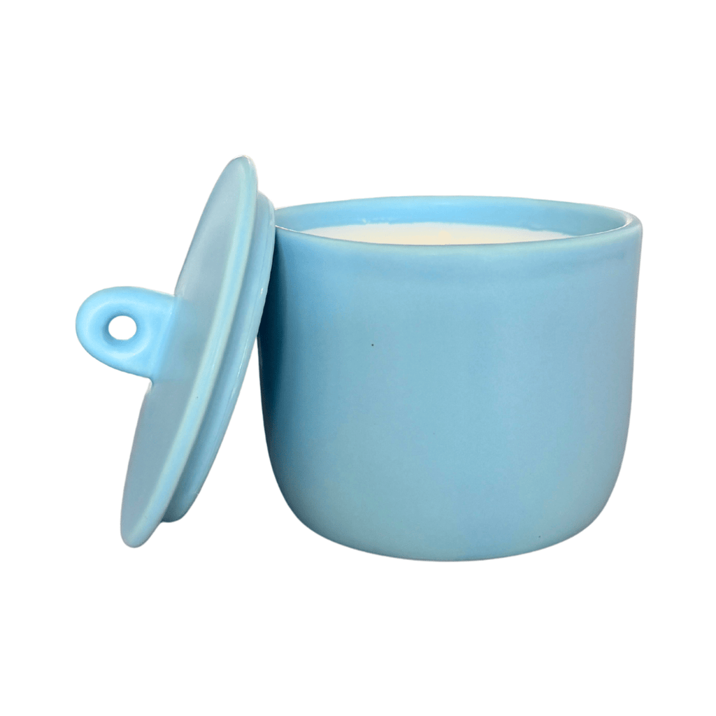 Blue ceramic candle with a matching lid on a white background