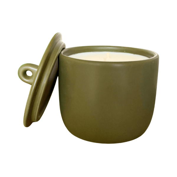 Green ceramic vessel with a candle inside on a white background