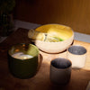 Ceramic bowls and a candle on a wooden surface