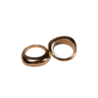 Two smooth, rounded metallic rings in a warm gold finish, positioned side-by-side on a solid white background.
