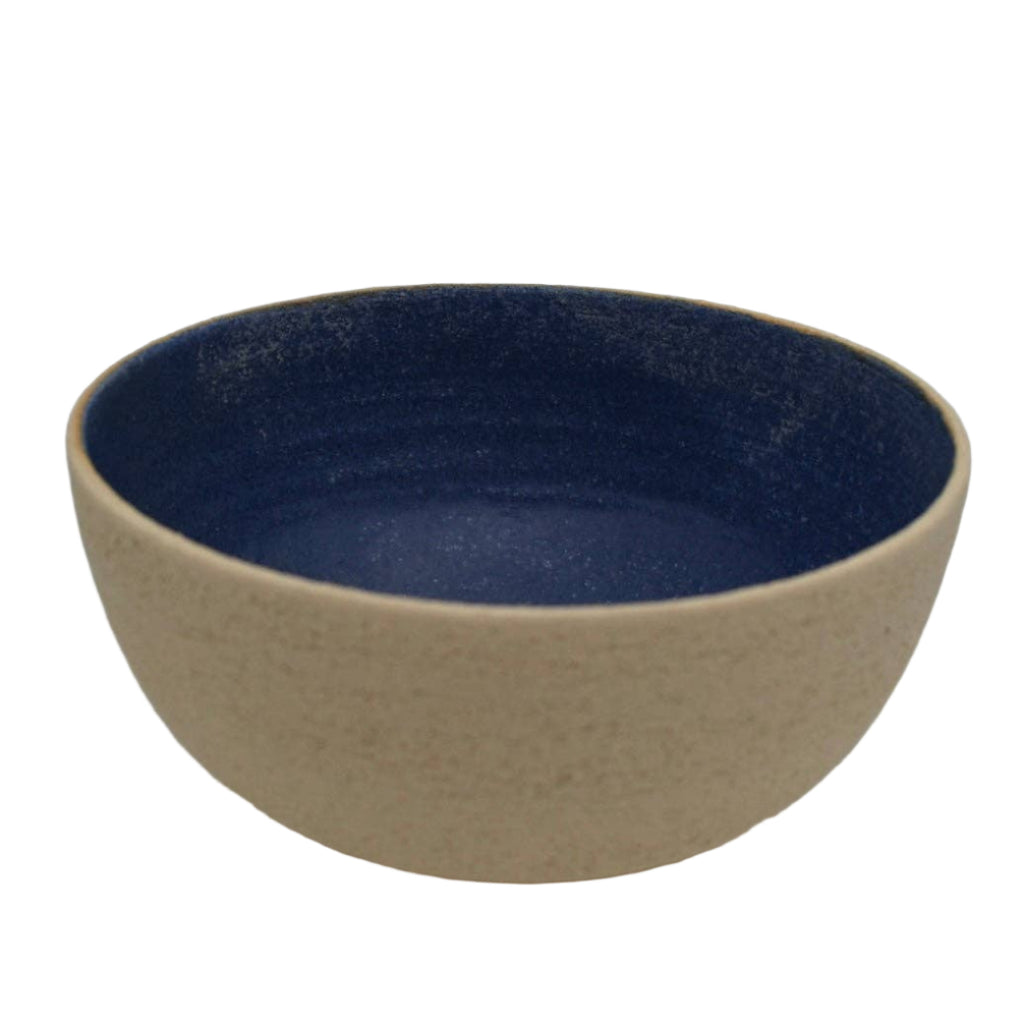 Ceramic bowl with blue interior and beige exterior on a white background