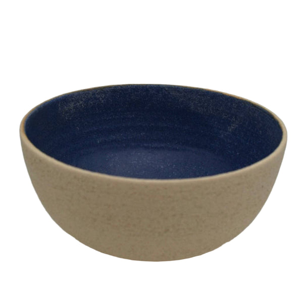 Ceramic bowl with blue interior and beige exterior on a white background