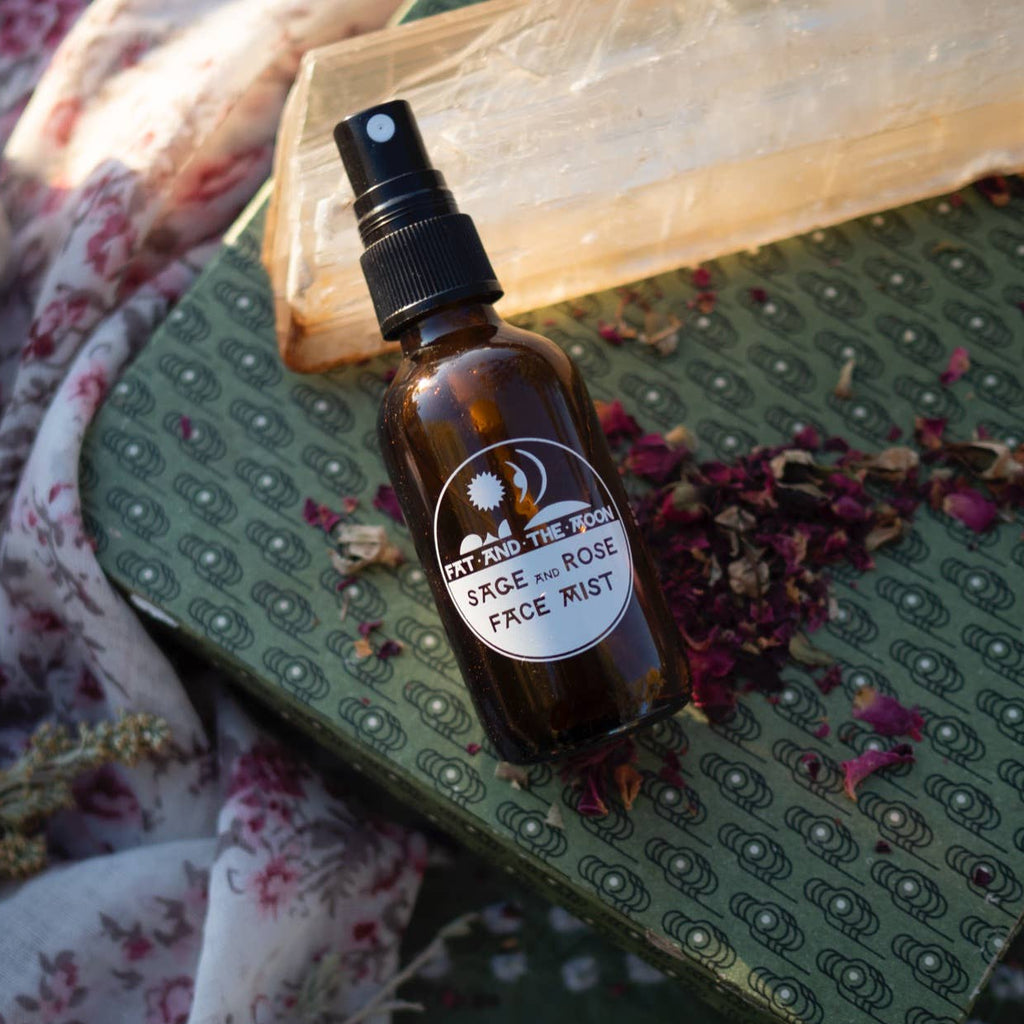Brown glass bottle with a label on a green textured surface with dried flowers and a floral cloth.