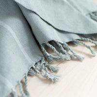 Light blue towel with tassels on a light background