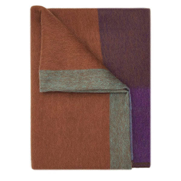 Folded fabric with brown, purple, and green colors on a white background