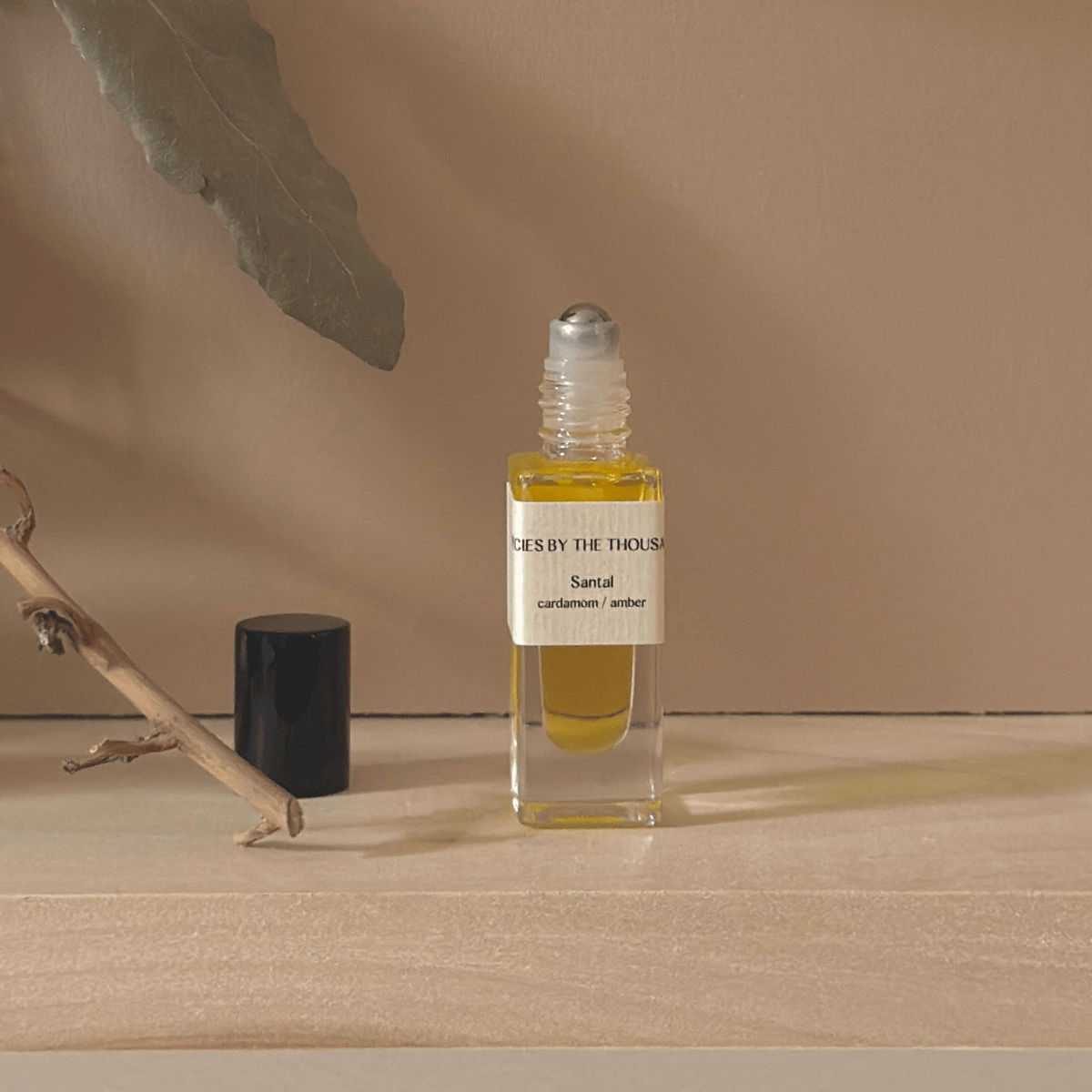 Small glass bottle with yellow liquid on a beige surface with a neutral background