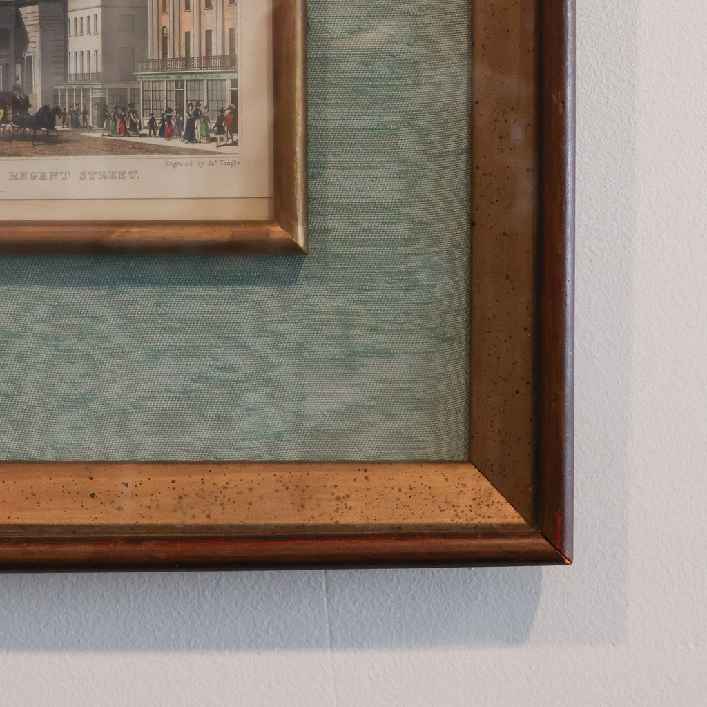 Framed artwork with a detailed brown frame on a light gray wall.