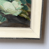 Close-up of a framed painting with a signature on a white background