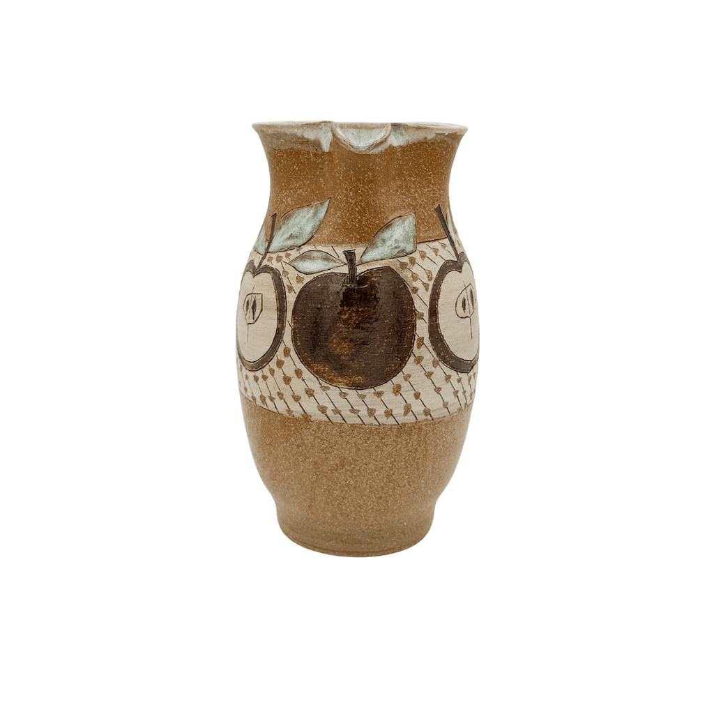 Ceramic pitcher with apple design on a white background