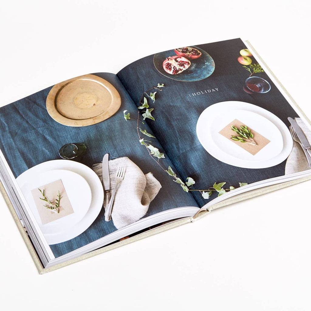 Open book showing images of table settings and food on a white background