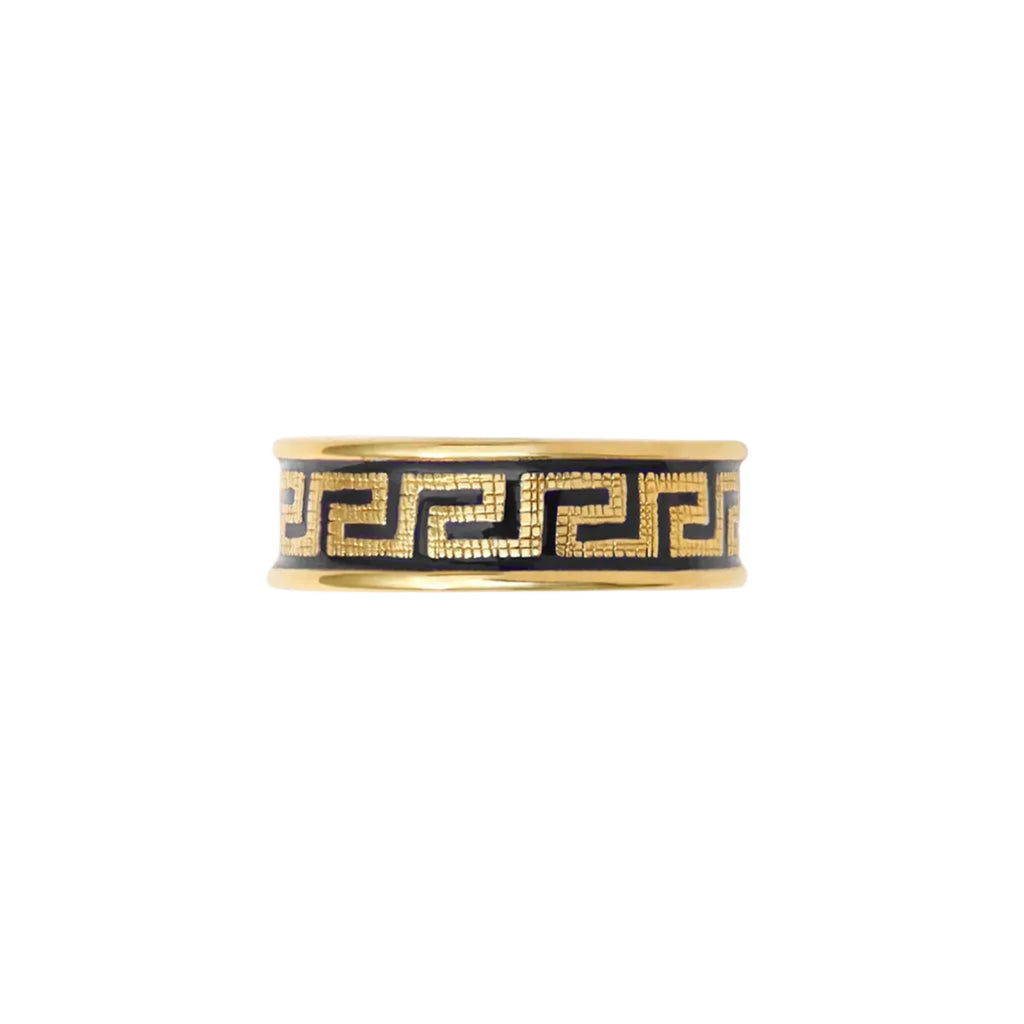 Gold and black patterned ring on a white background