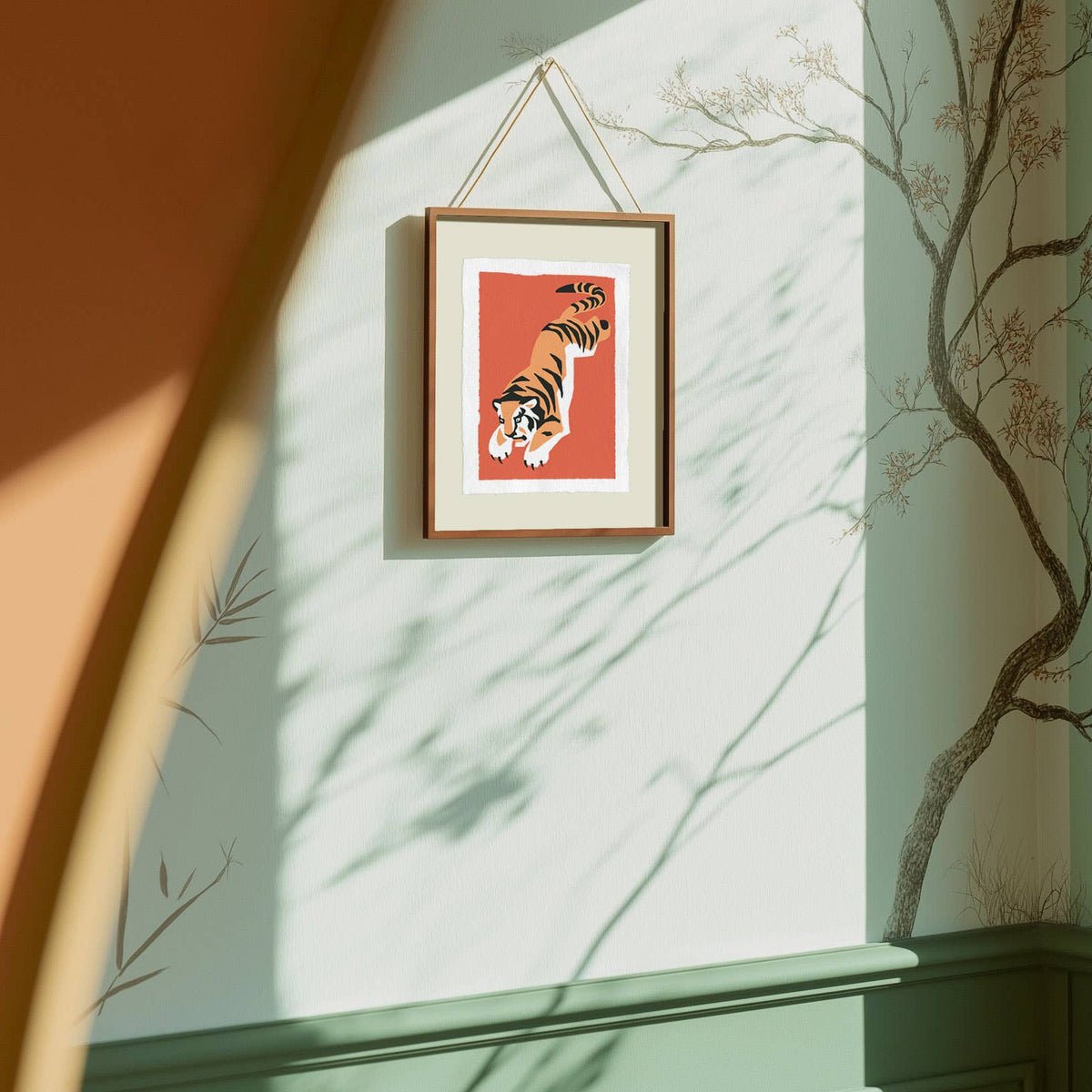 Framed artwork of a tiger on a wall with sunlight casting shadows.
