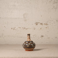Decorative ceramic vase with floral patterns on a textured surface and background