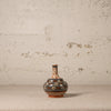 Decorative ceramic vase with floral patterns on a textured surface and background