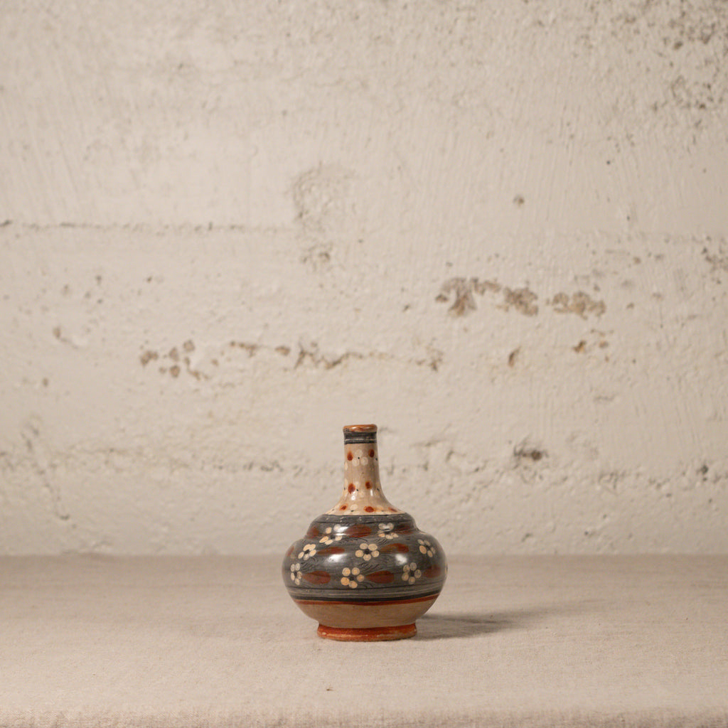Decorative ceramic vase with floral patterns on a textured surface and background