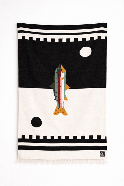 handwoven towel with fish design on a black and white background