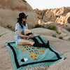 Woman sitting on a colorful rug with desert landscape in the background