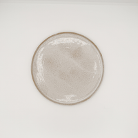 Round ceramic plate with a textured surface on a white background
