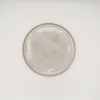Round ceramic plate with a textured surface on a white background