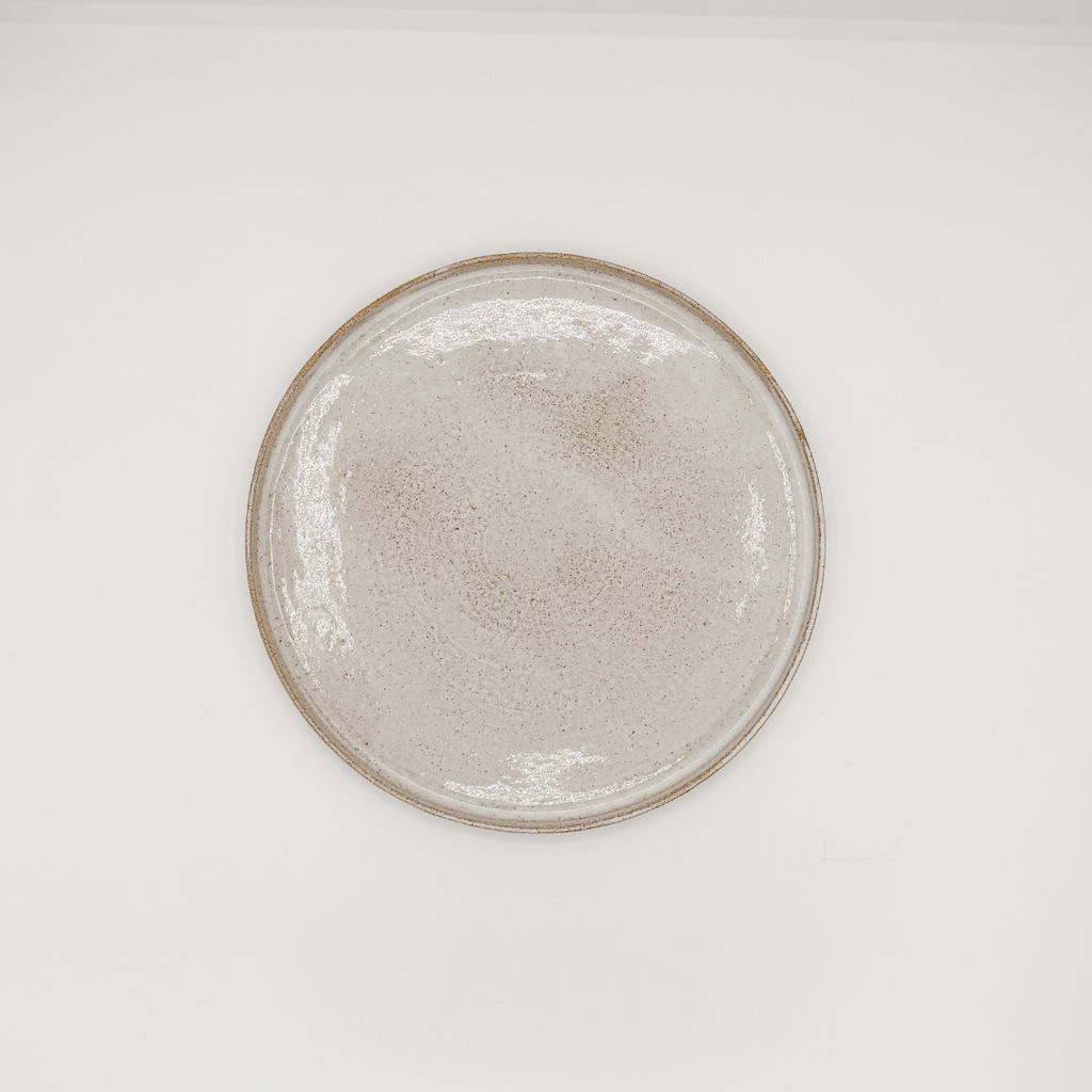 Round ceramic plate with a textured surface on a white background