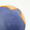 Close-up of a blue and orange textured plate on a white background