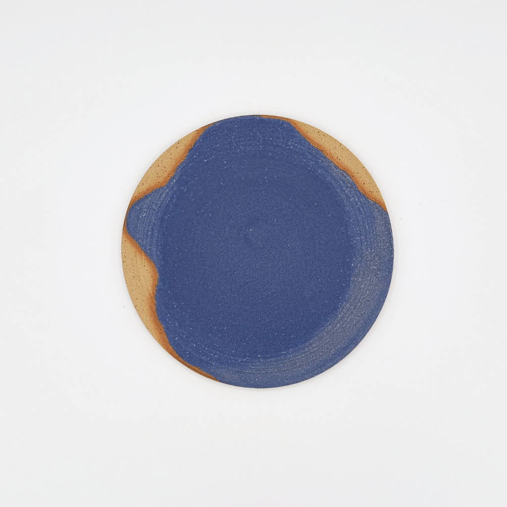 Round ceramic plate with blue and brown design on a white background