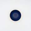 Navy blue ceramic bowl with beige rim on a white background