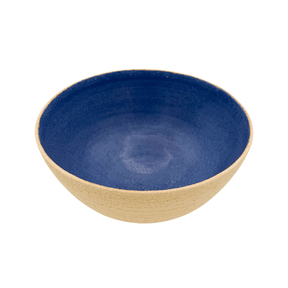 Blue ceramic bowl with beige rim on a white background