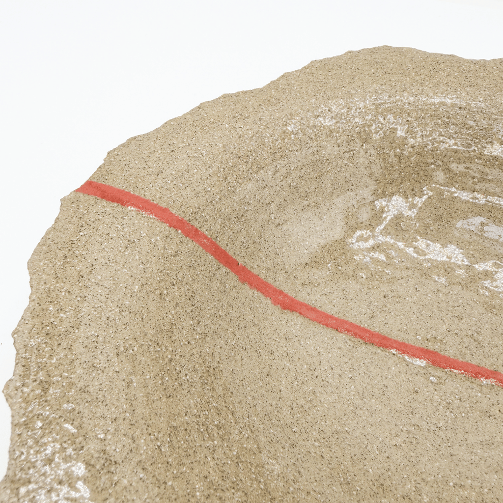 close up of stoneware plate with red line detail on white background