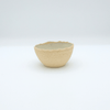 Small ceramic cup with textured surface on a white background