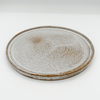Round ceramic plate with a textured surface on a white background
